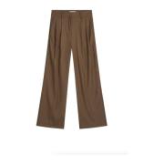 Brune bukser med karakteristiske folder ved linningen